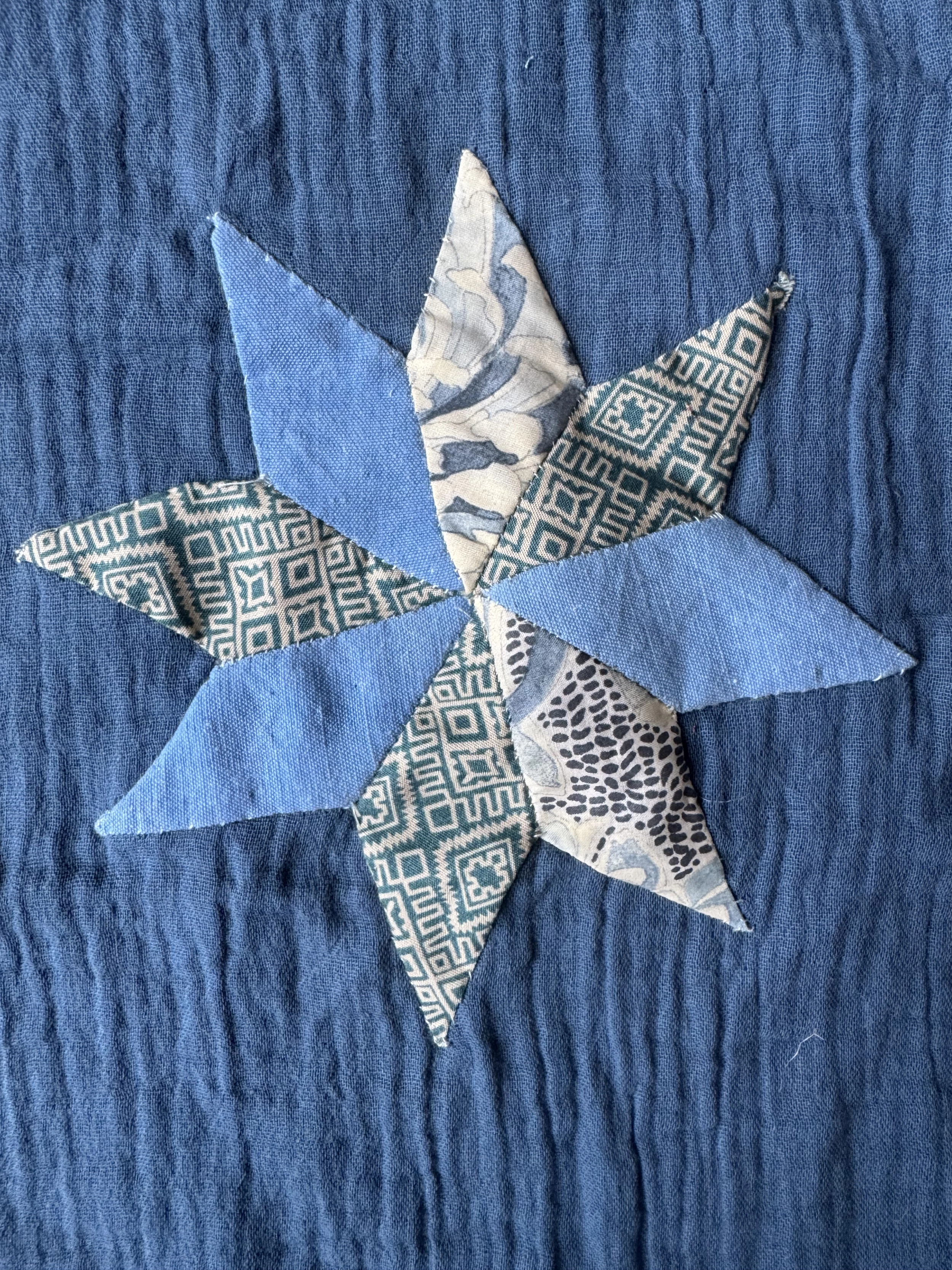An eight-point patchwork star in blue and patterned cloth